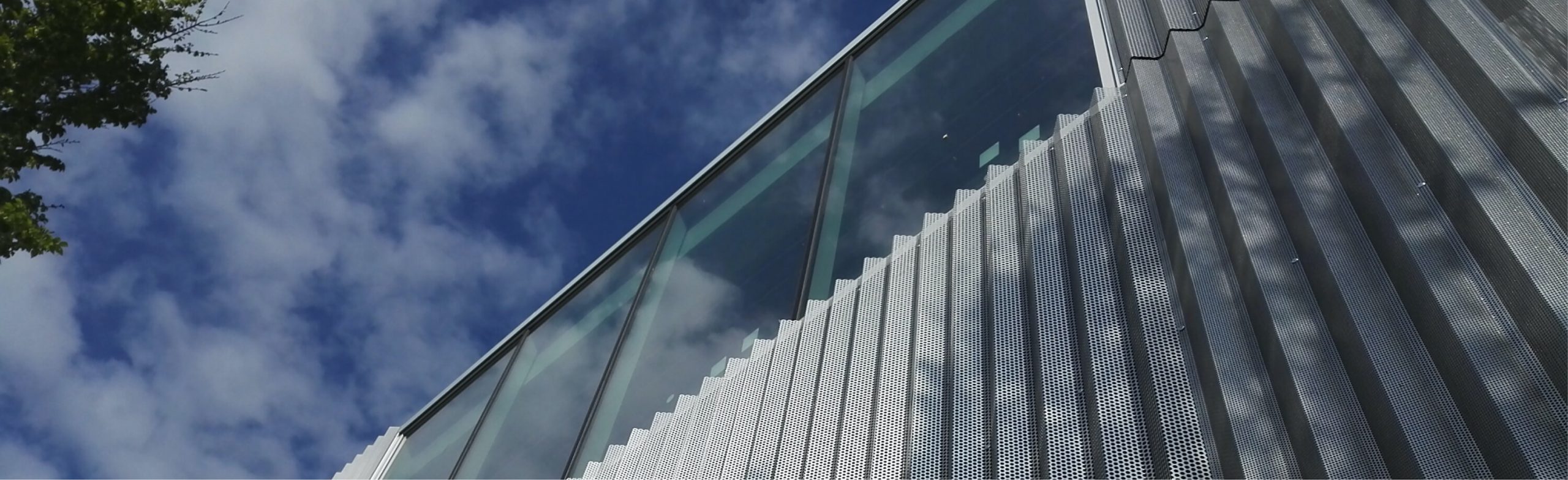 Façade de bâtiment avec baie vitrée et ciel bleu Ker Alu menuiserie aluminium Lorient